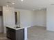 Open kitchen with an island, stainless steel appliances, and ceramic tile flooring at 22319 W Monona Ln, Surprise, AZ 85387