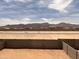 Backyard view features a block fence, open space, and mountain views in the distance at 22327 W Monona Ln, Surprise, AZ 85387