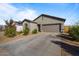 Single-story home with gray exterior, two-car garage, and landscaped front yard at 25587 N Boreas Rd, Florence, AZ 85132