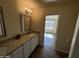 Bathroom with double vanity, granite countertop, and view of backyard at 25603 W Hedgehog Rd, Wittmann, AZ 85361