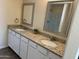 Double vanity bathroom with granite countertop, large mirrors, and a walk-in shower at 25603 W Hedgehog Rd, Wittmann, AZ 85361