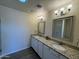 Double vanity bathroom with granite countertops, mirrors, and a shower at 25603 W Hedgehog Rd, Wittmann, AZ 85361