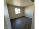 Spacious bedroom with wood-look tile flooring and a window with view at 25603 W Hedgehog Rd, Wittmann, AZ 85361