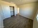 Bedroom with wood-look floors, a closet, and access to hallway at 25603 W Hedgehog Rd, Wittmann, AZ 85361