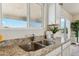 Bright kitchen featuring a stainless steel sink with granite counters and a view through the window at 25603 W Hedgehog Rd, Wittmann, AZ 85361