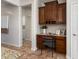 Built-in desk with wood cabinets, granite countertop, and chair in kitchen at 26637 W Irma Ln, Buckeye, AZ 85396