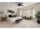 Main bedroom with large bed, seating area, and window seating at 26637 W Irma Ln, Buckeye, AZ 85396