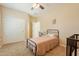 Light and airy bedroom with twin bed, ceiling fan, and double doors to closet at 2925 E Tonto Dr, Gilbert, AZ 85298