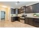 Spacious kitchen with dark wood cabinets, granite countertops, and stainless steel appliances at 2925 E Tonto Dr, Gilbert, AZ 85298