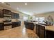 Open concept kitchen with island, granite countertops, and dark wood cabinets at 2925 E Tonto Dr, Gilbert, AZ 85298