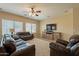 Spacious living room featuring dark brown leather furniture and a large flat-screen TV at 2925 E Tonto Dr, Gilbert, AZ 85298