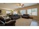 Spacious living room featuring dark leather couches and a ceiling fan at 2925 E Tonto Dr, Gilbert, AZ 85298