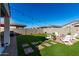 Landscaped backyard featuring artificial turf and firepit at 35170 W La Paz St, Maricopa, AZ 85138