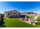 Artificial turf backyard with firepit and patio seating at 35170 W La Paz St, Maricopa, AZ 85138