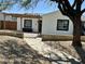 Charming single-story home featuring stucco walls, black-framed windows, and a wooden pergola for shaded outdoor seating at 4032 N 11Th Ave, Phoenix, AZ 85013