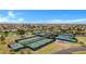 A high-angle view of a community featuring well-maintained tennis courts and lush landscaping for active living at 42085 W Morning Glory Way, Maricopa, AZ 85138