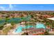 A sunny view of the community pool with palm trees, loungers, and a spacious area for relaxation and fun at 42085 W Morning Glory Way, Maricopa, AZ 85138