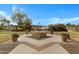 View of a landscaped courtyard featuring a sculpture, water, mature trees, and manicured lawn at 42085 W Morning Glory Way, Maricopa, AZ 85138