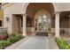 Close view of the building entrance, framed by white pillars, and featuring mature landscaping at 42085 W Morning Glory Way, Maricopa, AZ 85138