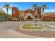 Elegant multi-colored community building featuring a fountain, palm trees, and well-maintained landscaping at 42085 W Morning Glory Way, Maricopa, AZ 85138
