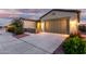 Beautiful home exterior with a stone-accented entrance, a two-car garage and landscaped yard at 42085 W Morning Glory Way, Maricopa, AZ 85138