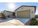 Two-car garage with light-colored doors and desert landscaping at 42085 W Morning Glory Way, Maricopa, AZ 85138