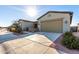 Two-car garage with light-colored doors and desert landscaping at 42085 W Morning Glory Way, Maricopa, AZ 85138