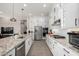 White kitchen with granite counters and stainless steel appliances at 42085 W Morning Glory Way, Maricopa, AZ 85138