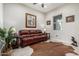 Living room with leather couch, wood floors, and western decor at 42085 W Morning Glory Way, Maricopa, AZ 85138