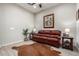 Living room with leather couch, wood floors, and western decor at 42085 W Morning Glory Way, Maricopa, AZ 85138