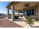 Covered patio with seating area and pond view at 42085 W Morning Glory Way, Maricopa, AZ 85138