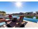 Sun-drenched patio with fire pit and comfortable seating overlooking the lake at 42085 W Morning Glory Way, Maricopa, AZ 85138