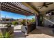 Relaxing patio with wicker furniture under pergola at 42085 W Morning Glory Way, Maricopa, AZ 85138