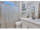 Clean bathroom with white vanity, striped shower curtain at 44622 N Sonoran Arroyo Ln, New River, AZ 85087