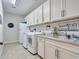 Bright laundry room with white cabinets, washer, dryer, and sink at 44622 N Sonoran Arroyo Ln, New River, AZ 85087