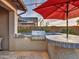 Outdoor kitchen with grill, bar seating, and red umbrella at 44622 N Sonoran Arroyo Ln, New River, AZ 85087