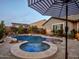 Inviting pool and spa with a waterfall, surrounded by a stone patio at 44622 N Sonoran Arroyo Ln, New River, AZ 85087