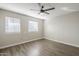 Well-lit bedroom with two windows, ceiling fan, and wood-look floor at 4565 N 26Th Dr, Phoenix, AZ 85017