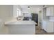 White kitchen with quartz countertops and black appliances. View of the bathroom is partially visible at 4565 N 26Th Dr, Phoenix, AZ 85017