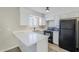 Modern kitchen with white cabinets, quartz countertops, and black appliances at 4565 N 26Th Dr, Phoenix, AZ 85017