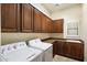 Bright laundry room with ample wood cabinets and space for full-size washer and dryer at 4655 E Indigo St, Gilbert, AZ 85298