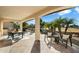 Covered patio with dining area, seating, and a fire pit overlooking a tranquil water feature at 4655 E Indigo St, Gilbert, AZ 85298