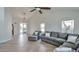 Bright living room with gray sectional sofa and herringbone floors at 4818 E Dartmouth Cir, Mesa, AZ 85205