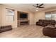 Living room featuring a modern fireplace and brown leather sectional at 494 S 220Th Ln, Buckeye, AZ 85326