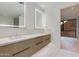 Modern bathroom with dual sinks, wood cabinets and an excellent view of nature at 5000 N Camelback Ridge Dr # 301, Scottsdale, AZ 85251