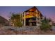 Elegant multi-story building with large windows and well-lit balconies at dusk at 5000 N Camelback Ridge Dr # 301, Scottsdale, AZ 85251