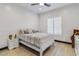 Bright bedroom with white sleigh bed, wood floors, and plantation shutters at 6105 N 174Th Ave, Waddell, AZ 85355