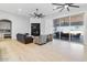 Bright living room with fireplace, hardwood floors, and sliding glass doors leading to the backyard at 6105 N 174Th Ave, Waddell, AZ 85355