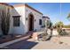 Front view of a Spanish-style home with brick walkway and landscaping at 7957 E Cave Creek Rd, Carefree, AZ 85377