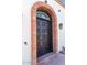 Ornate dark wood front door with brick archway and stained glass accents at 7957 E Cave Creek Rd, Carefree, AZ 85377